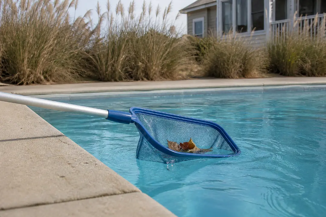 A pool skimmer removes leaves from a pool beside a coastal Surfside Beach home.